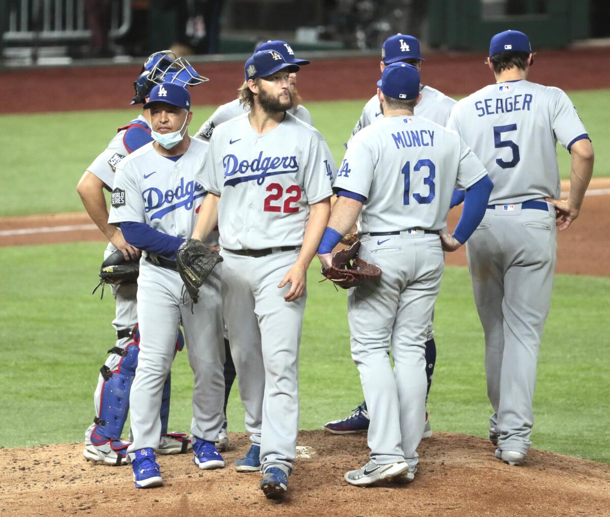 Clayton Kershaw walks off the mound surrounded by teammates