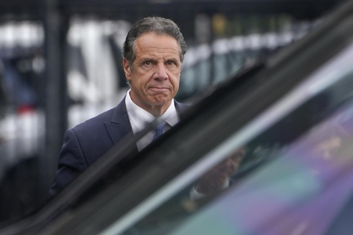 Andrew Cuomo is shown behind a car 