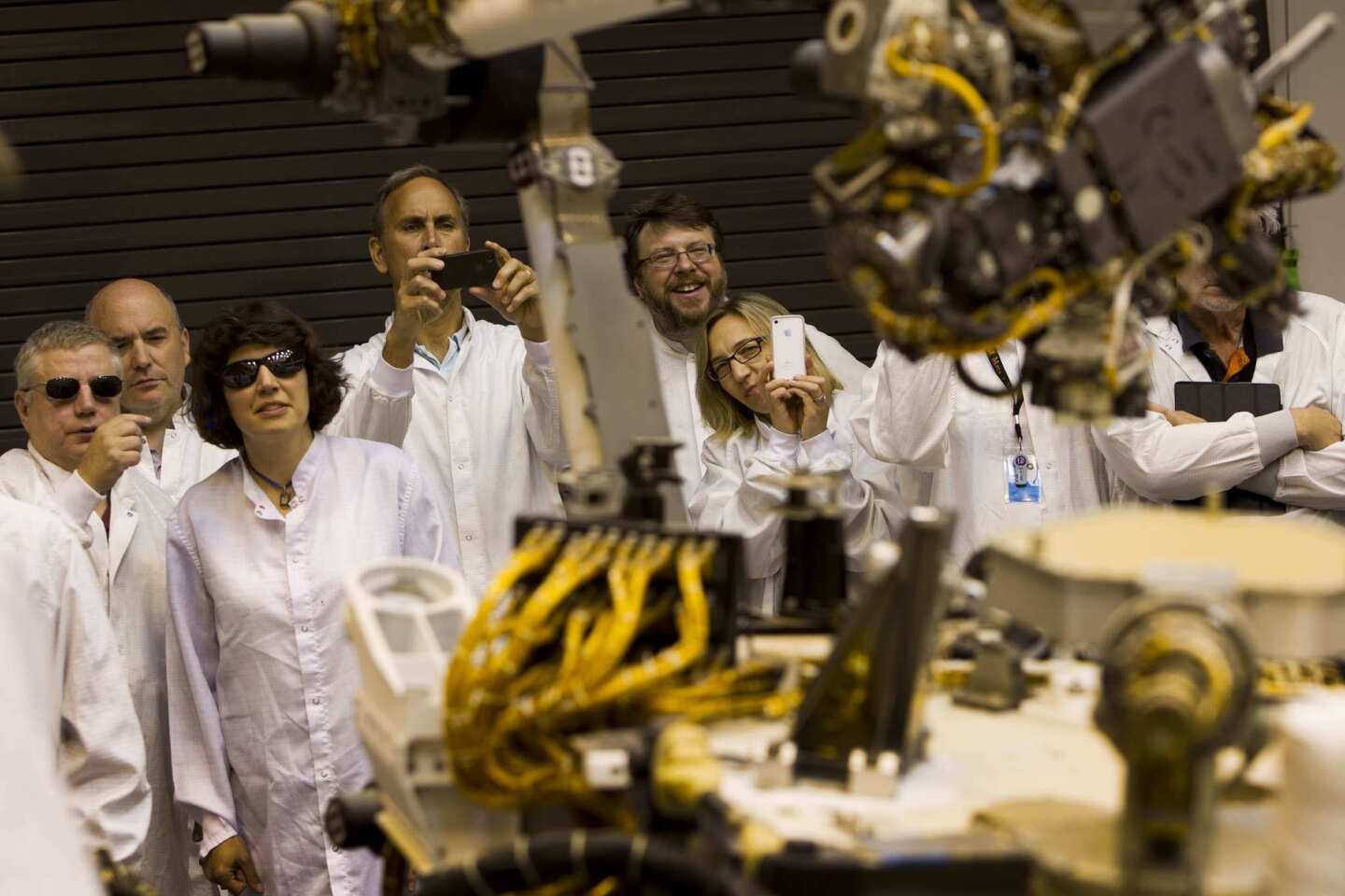JPL's John Grotzinger, center left, and other scientists take pictures during the surface science and sampling end-to-end thread test of the Mars rover.