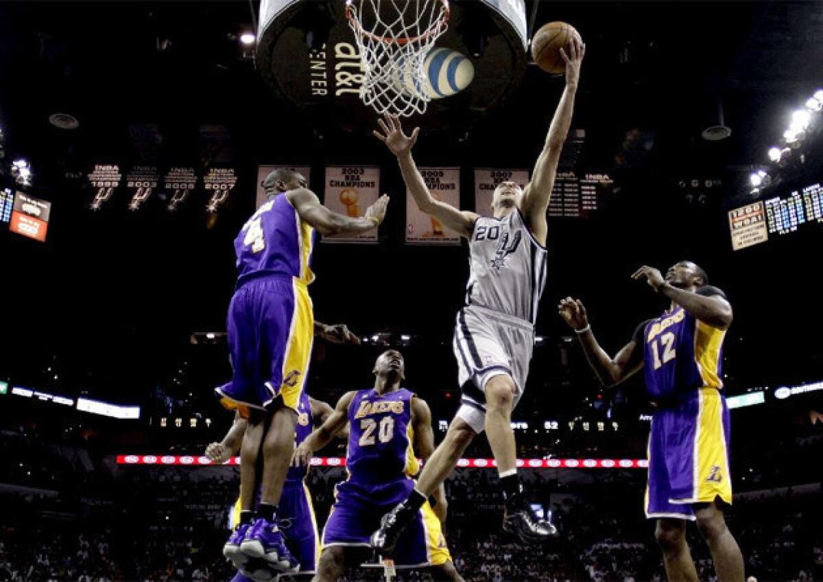 San Antonio Spurs guard Manu Ginobili drives to the basket past four Lakers.