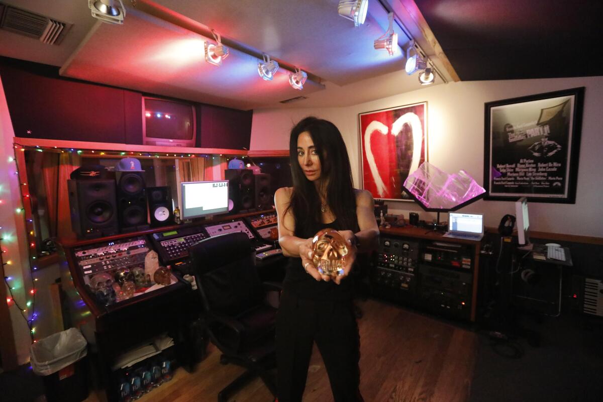 Songwriter and producer Antonina Armato holds a crystal skull inside her recording studio.