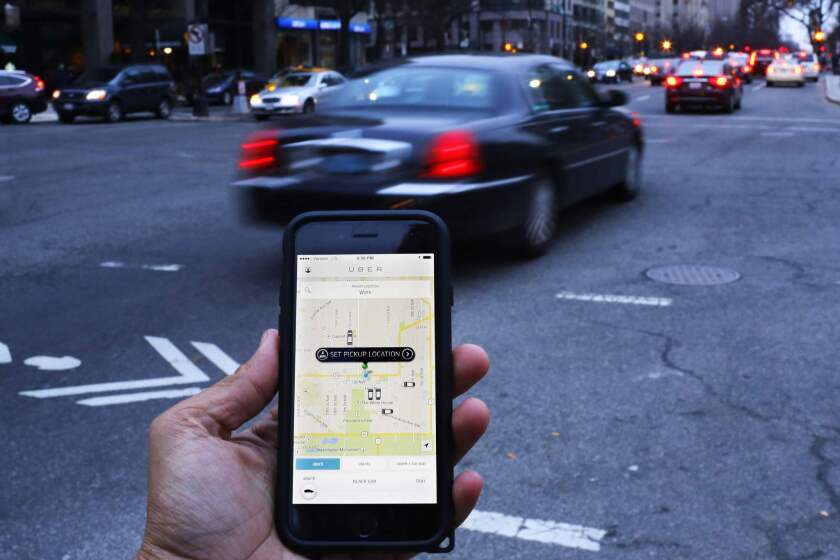 Who gets the benefit?This file photo shows the Uber smartphone app, being used by a passenger in Washington, D.C.