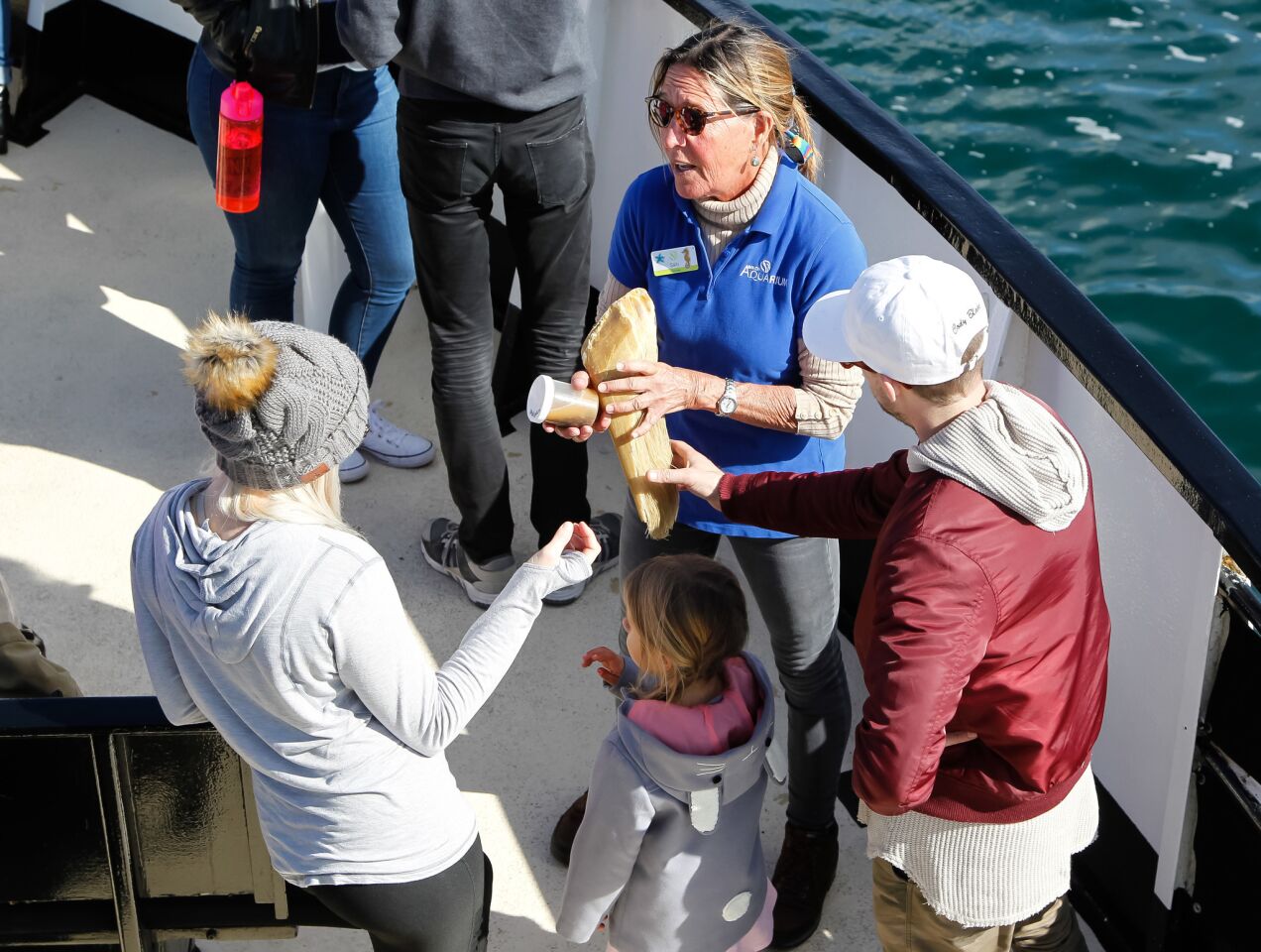 Volunteer Sally Beach shows baleen and from a gray whale to passengers aboard the Marietta after returning from a whale watching tour presented by Birch Aquarium and Flagship Cruises.