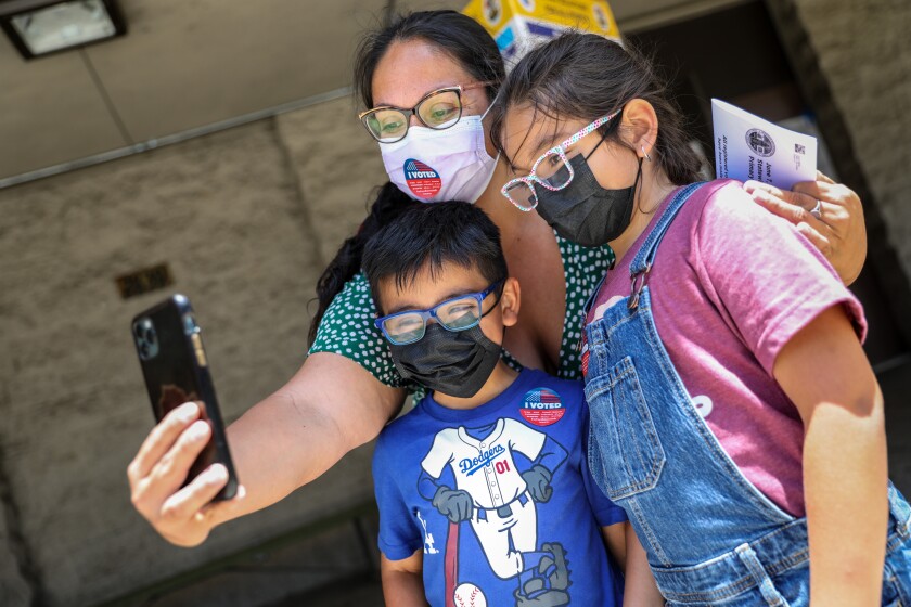 Hermilia Bustamante takes a selfie with her kids after voting.