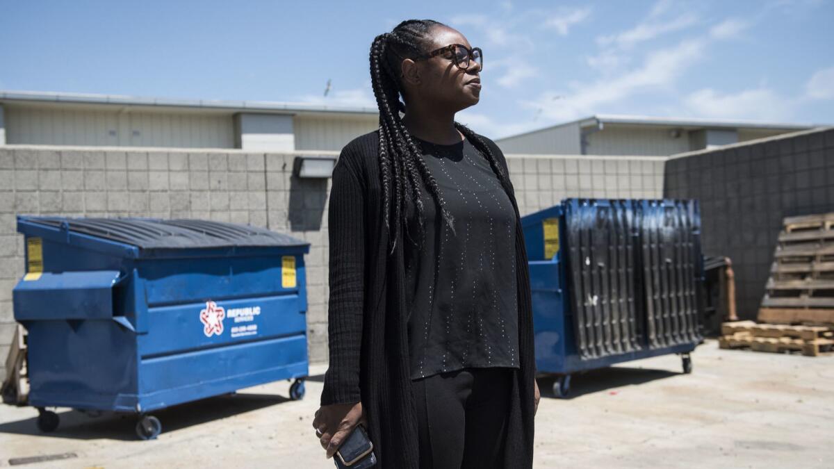 Magnolia Principal Shandrea Daniel stands in front of the dumpsters that occupy the area between her classroom buildings. She'd like them removed or enclosed.