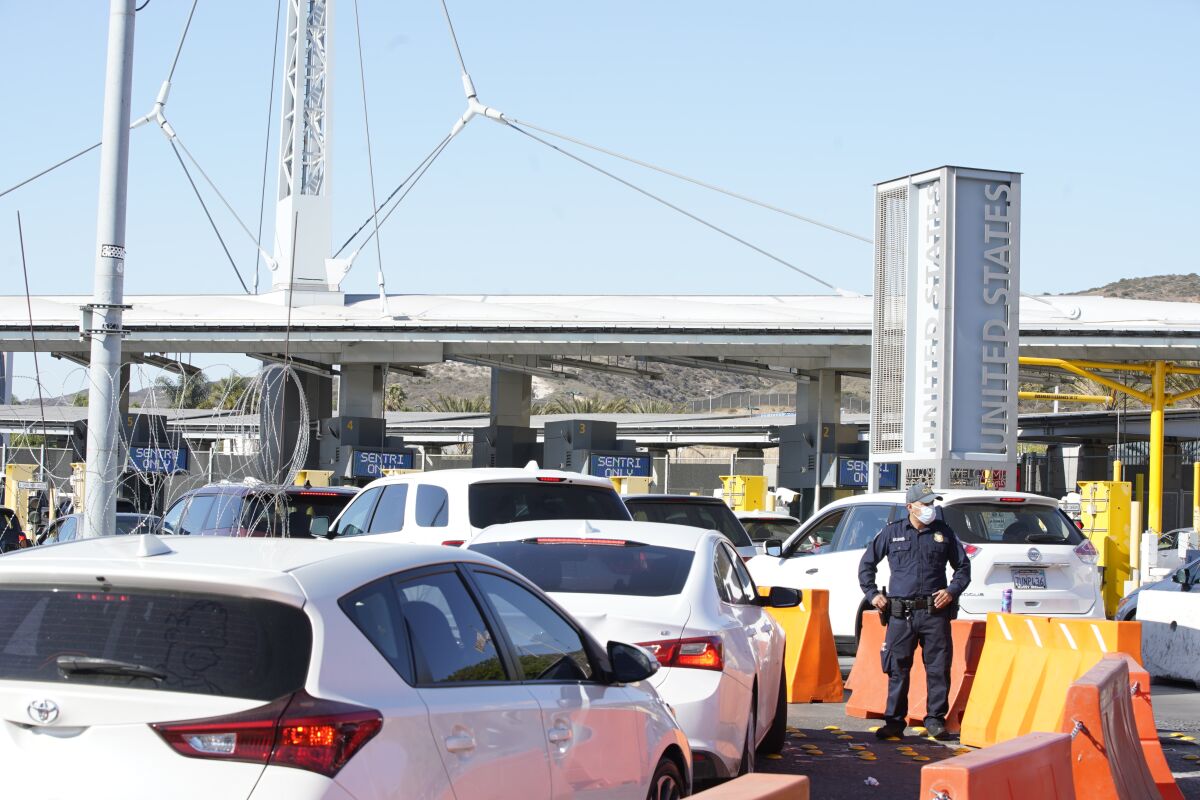 A U.S. Customs and Border Protection officer looks over vehicles passing at the San Ysidro Port of Entry on Oct. 13.