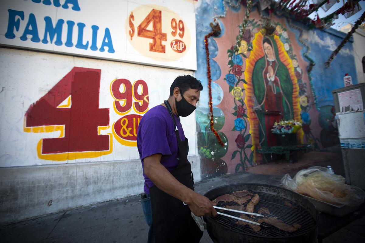 Clemente Gomez cooks carne asada on the grill outside a food truck in the Westlake neighborhood of Los Angeles.