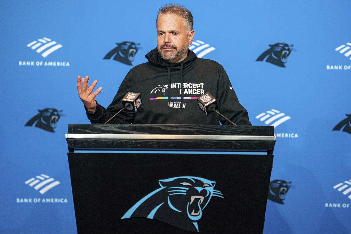 Carolina Panthers head coach Matt Rhule speaks during a news conference at a lectern.
