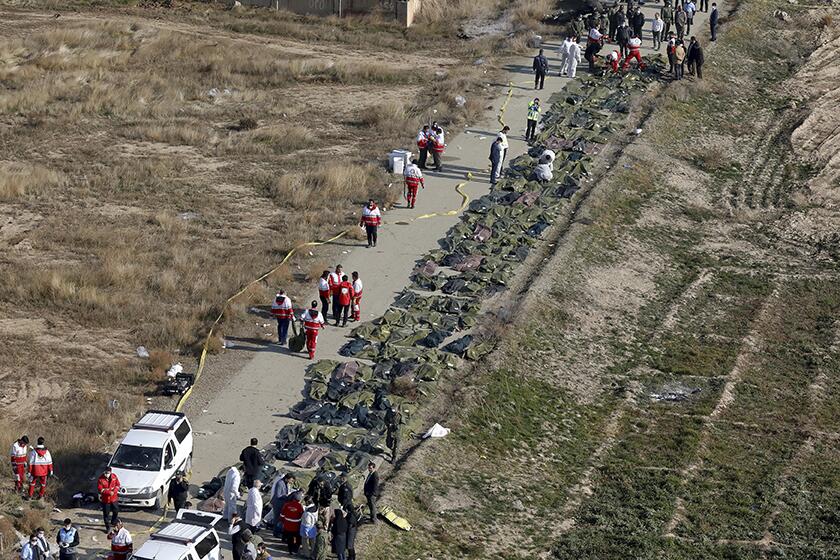 Bodies are collected by a rescue team after a jetliner crashed near Tehran on Wednesday, killing all 176 people on board.