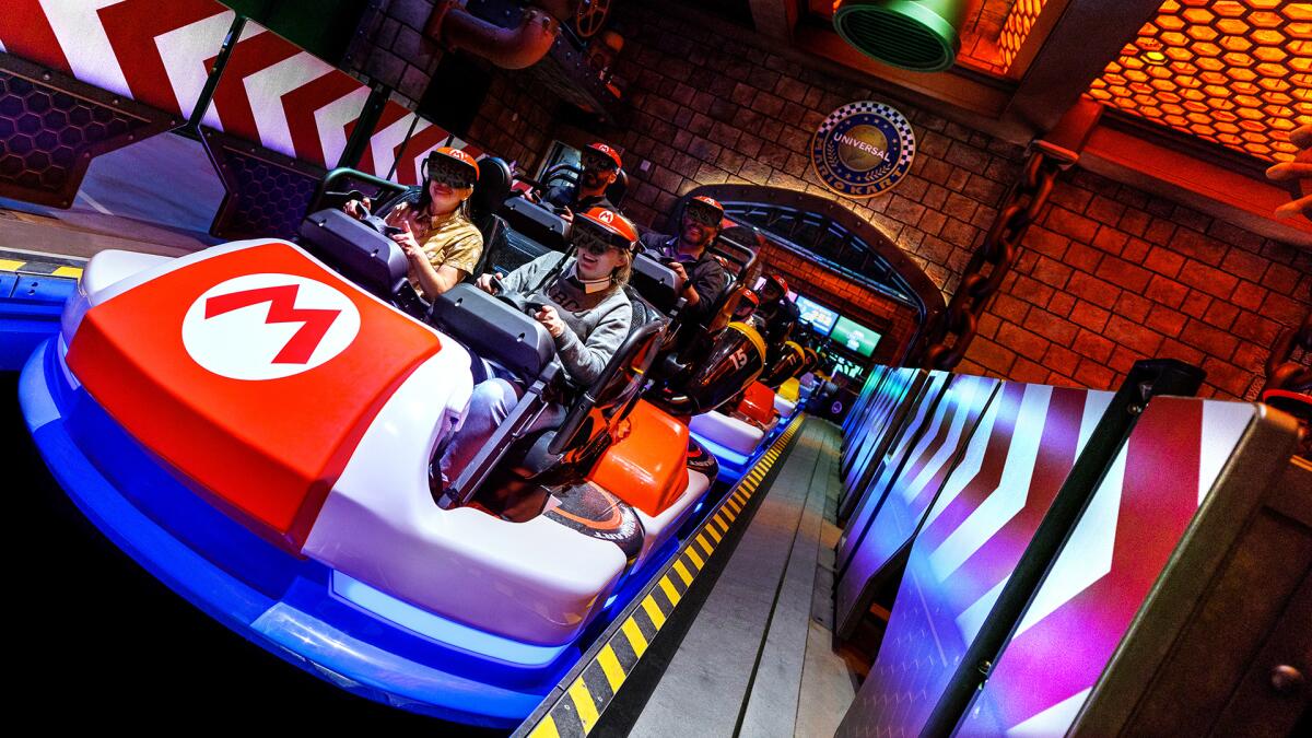 Guests board karts and don goggles for Mario Kart: Bowser's Challenge.