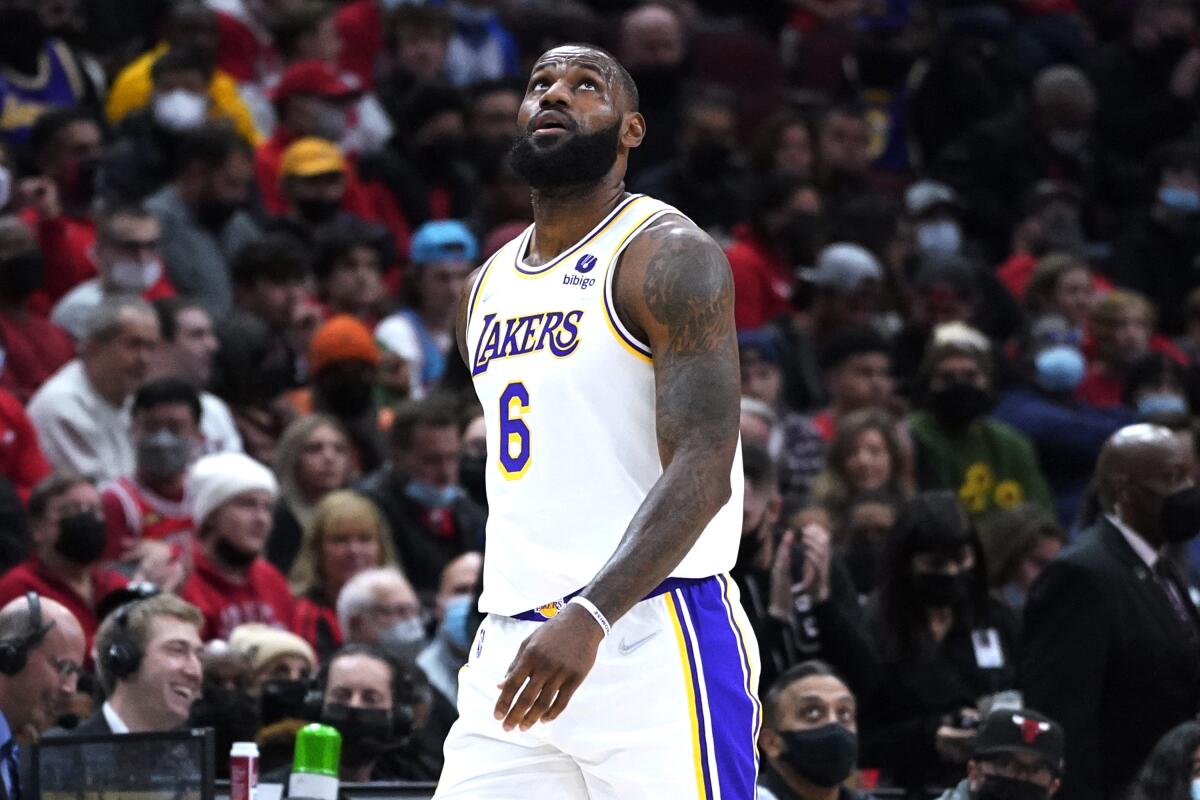 Lakers star LeBron James looks up the scoreboard as he walks to the bench.