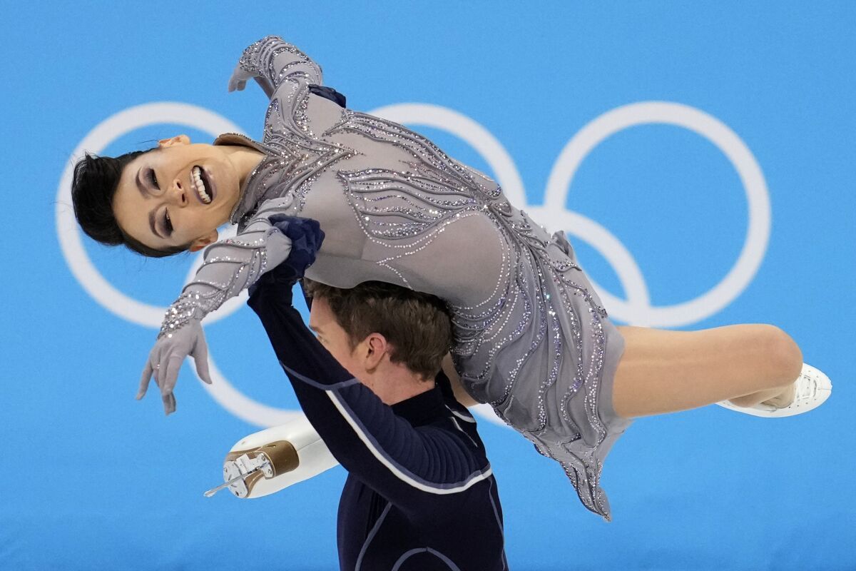 Evan Bates lifts Madison Chock over his head during their free dance routine.
