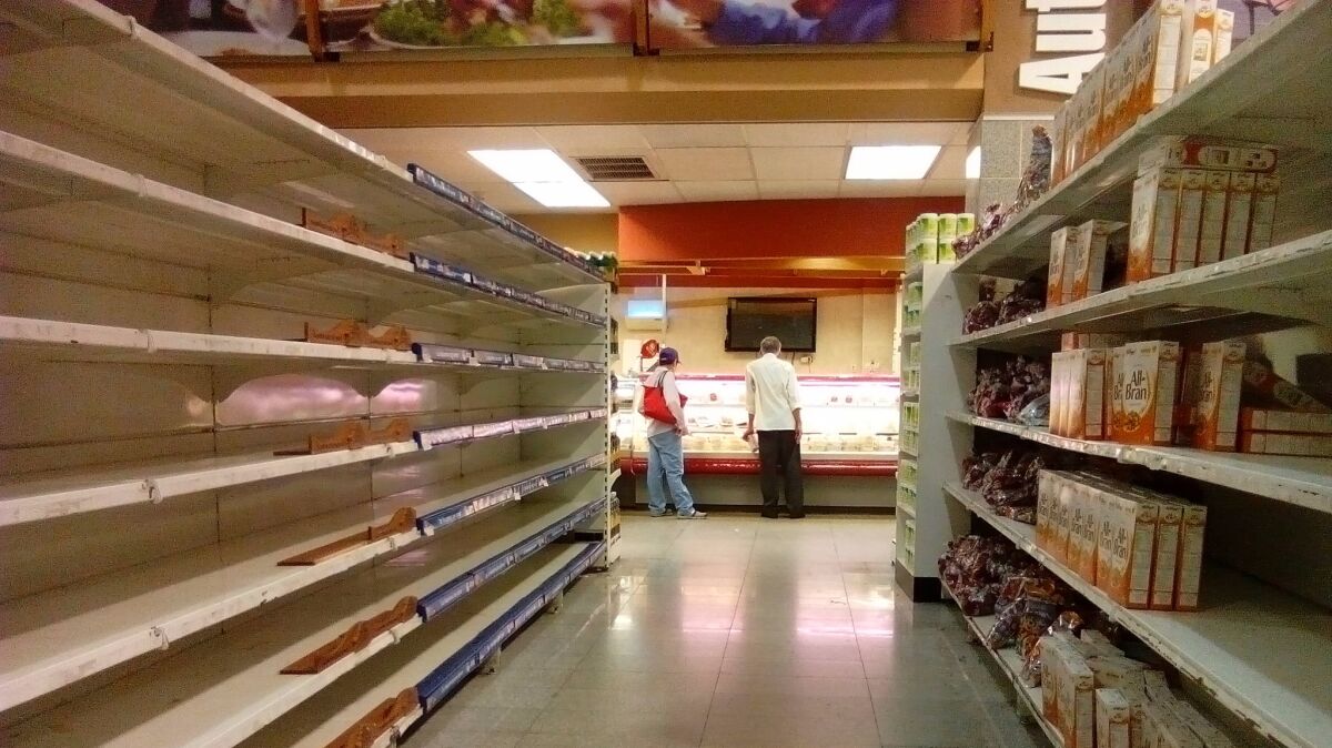 Empty shelves in a supermarket in Caracas illustrate the ongoing food shortages afflicting Venezuela.