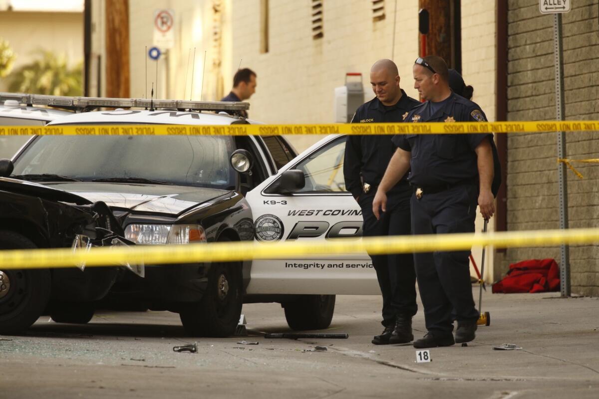 The California Highway Patrol's Major Accident Investigation Team inspects the scene in an alley near Glendale Boulevard and Harvard Street in Glendale, where a man suspected of taking off with a West Covina police car was killed in an officer-involved shooting.
