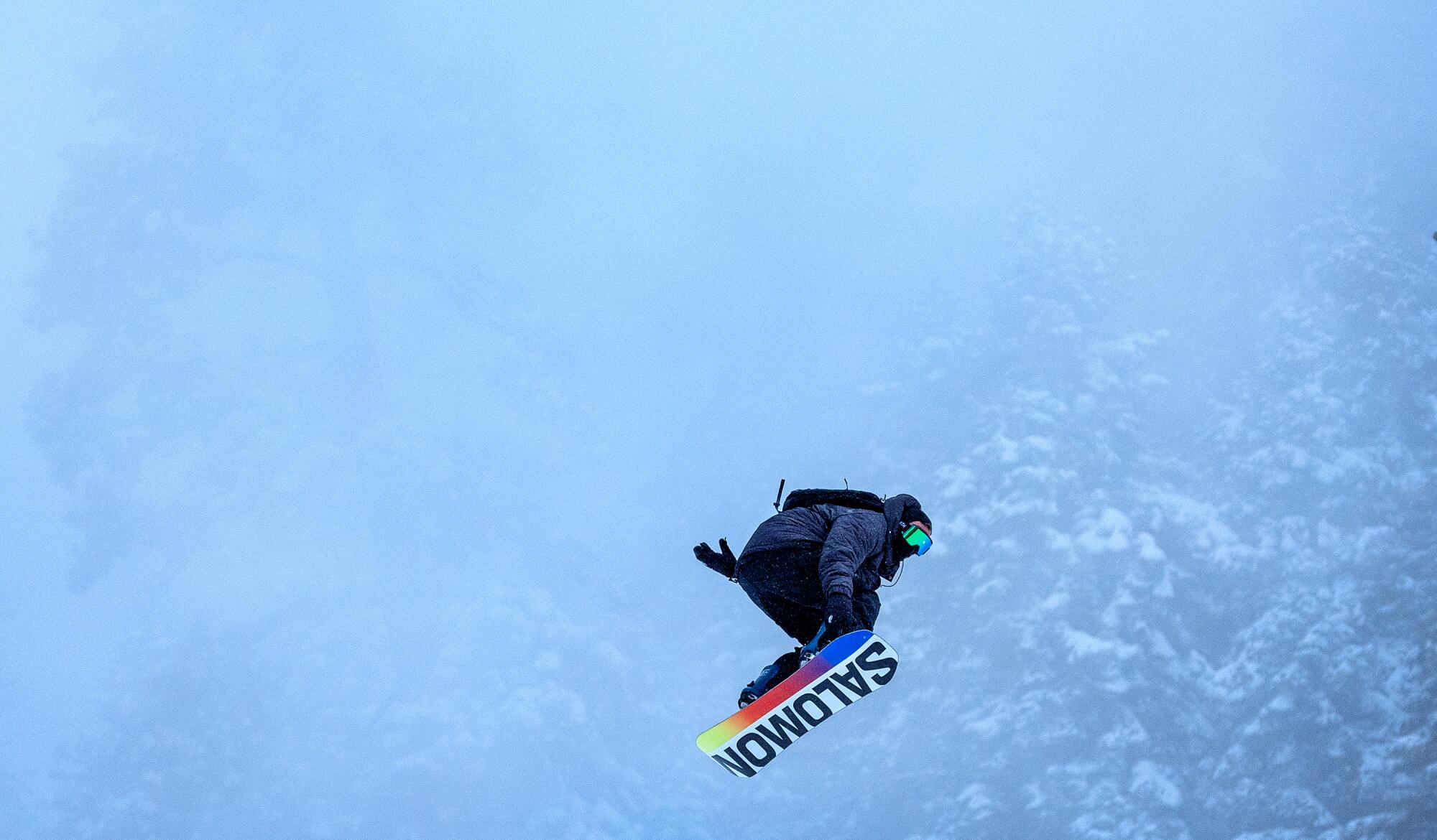 A snowboarder takes to the air.