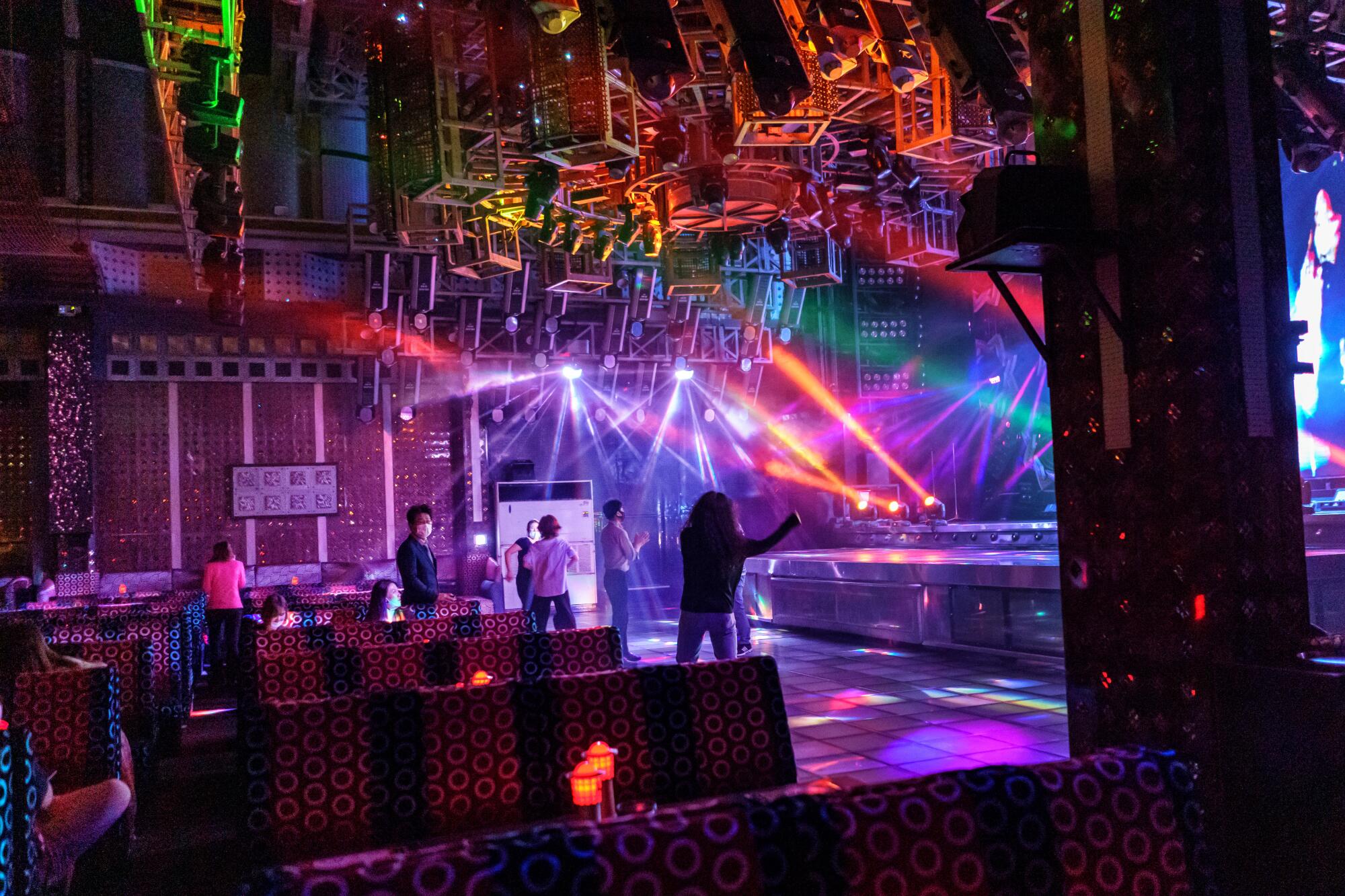 Patrons mingle on a nightclub dance floor.