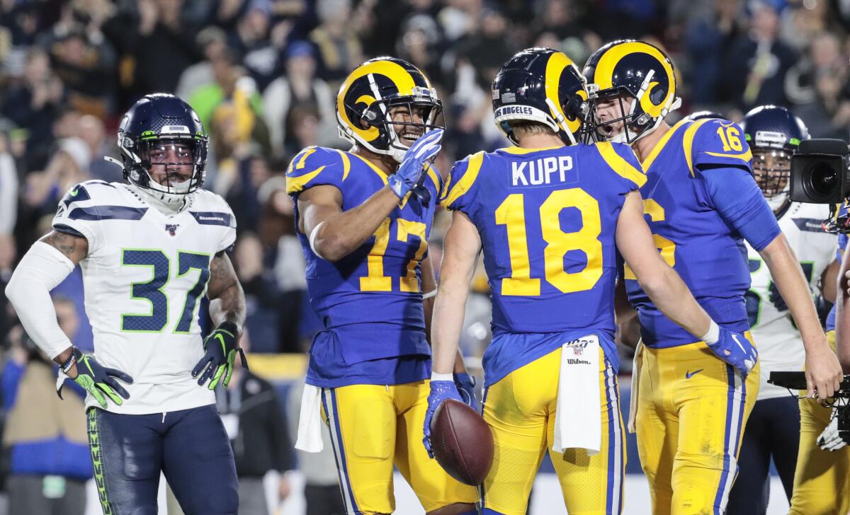 Rams quarterback Jared Goff (16) celebrates after throwing a touchdown pass to receiver Cooper Kupp (18) against the Seattle Seahawks at the Coliseum on Dec. 8.