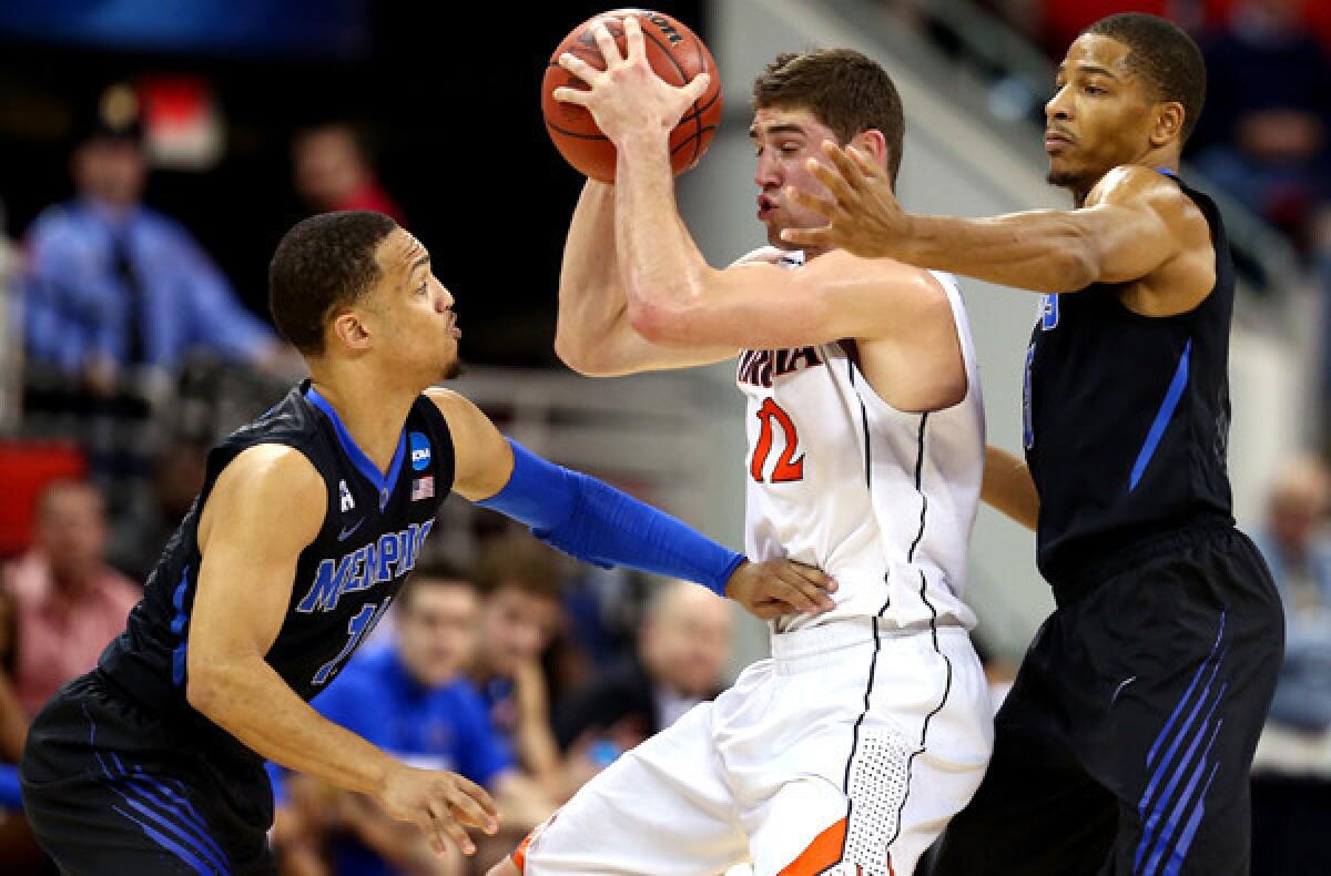 Virginia forward Joe Harris works in the post against the double-team defense of Memphis guard Michael Dixon Jr., left, and forward Nick King in the second half Sunday.