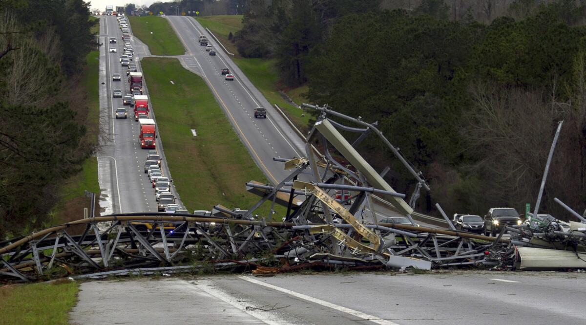 A fallen cell tower lies across U.S. Route 280 highway in Lee County, Ala. on Sunday.