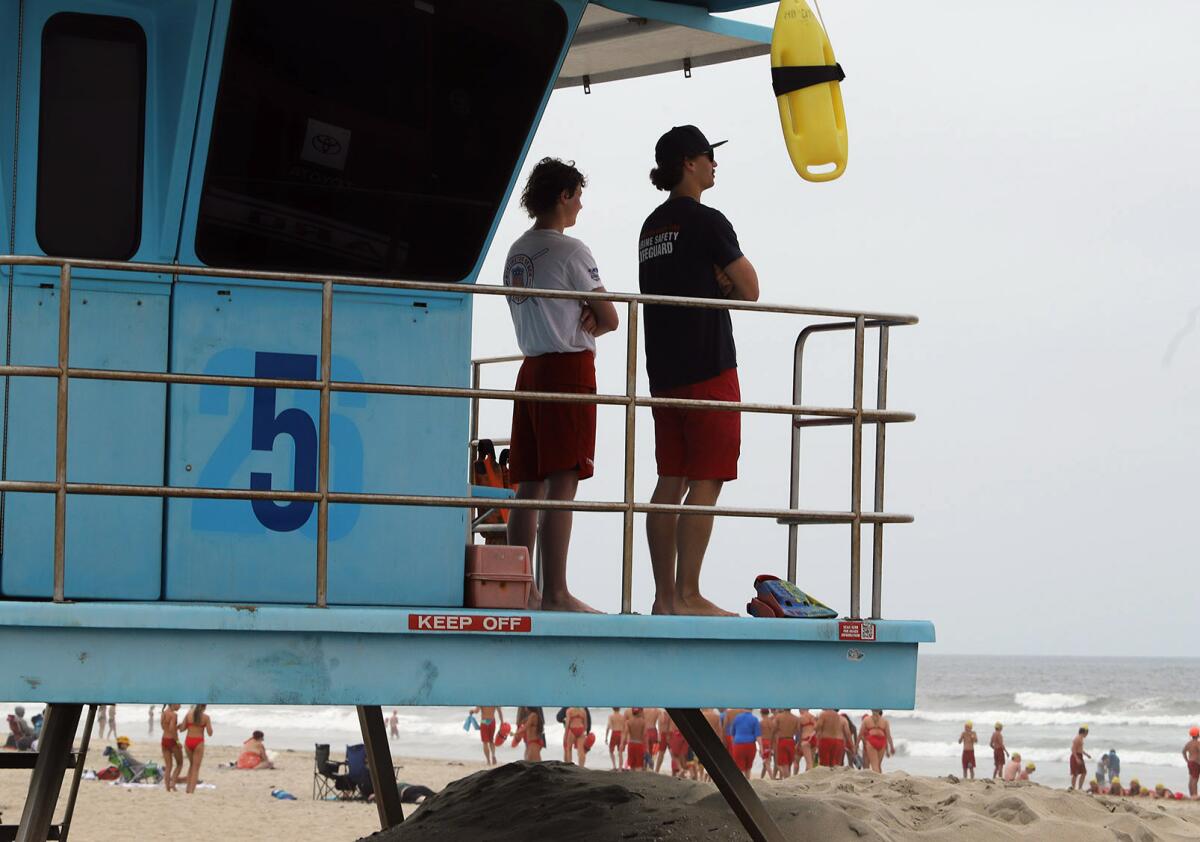Illinois Cooney, a junior lifeguard visiting from New Zealand, left, and Huntington Beach Lifeguard Sam Smith.