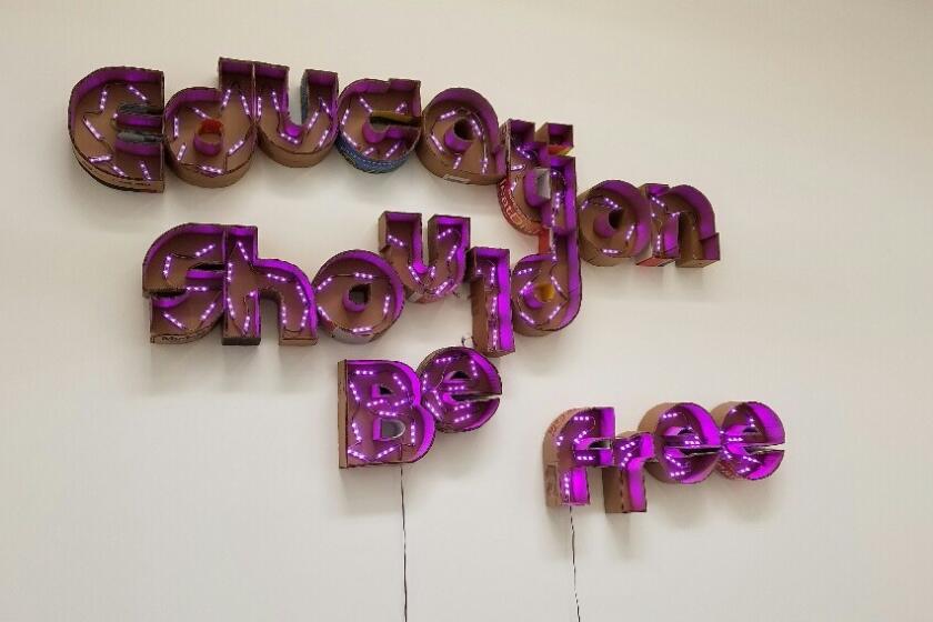 Andrea Bowers' sign, "Education Should Be Free," is made from electric lights in cut-up cardboard shipping boxes.