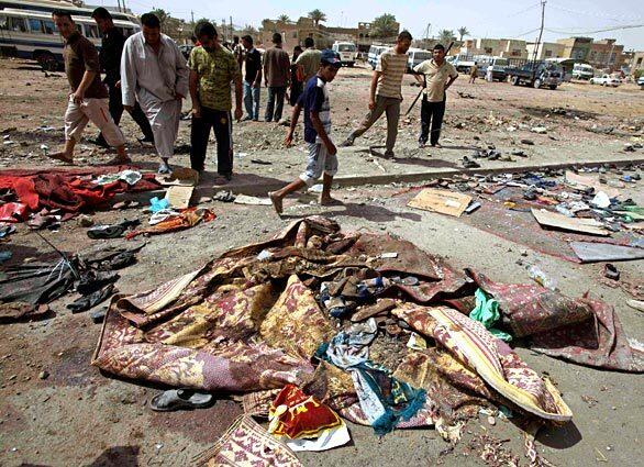 People gather at the site of a car bomb explosion in a parking lot next to a Shiite mosque in the neighborhood of Shaab in Baghdad.