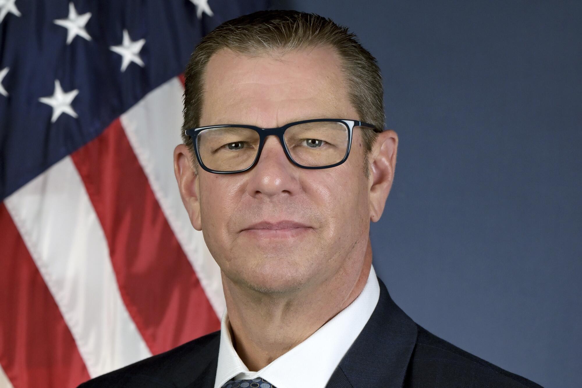 CARB chief Steven Cliff, wearing glasses and a suit, stands in front of an American flag.