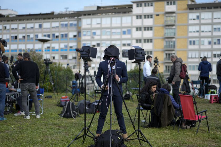 Members of the media set up their gear outside the Agostino Gemelli hospital under the rooms on the top floor normally used when a pope is hospitalised, in Rome, Thursday, March 30, 2023, after The Vatican said Pope Francis has been taken there in the afternoon for some scheduled tests. The Vatican provided no details, including how long the 86-year-old pope would remain at Gemelli University Hospital, where he underwent surgery in 2021. But his audiences through Friday were canceled, raising questions about Francis' participation during the Vatican's Holy Week activities starting Sunday. (AP Photo/Andrew Medichini)