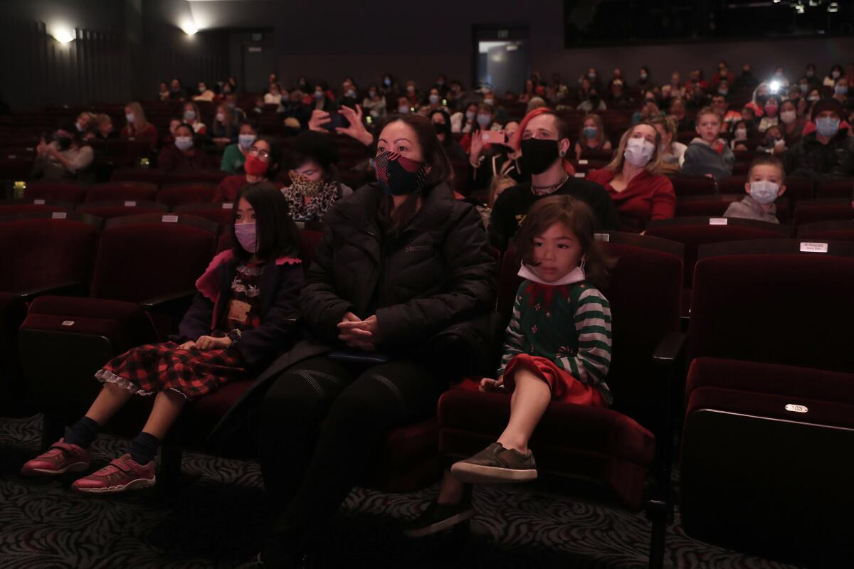 Rhea Hinojosa, of Mission Viejo, sits with her son, Raizo, 5, right, and daughter, Amara, 7, at "The Nutcracker."