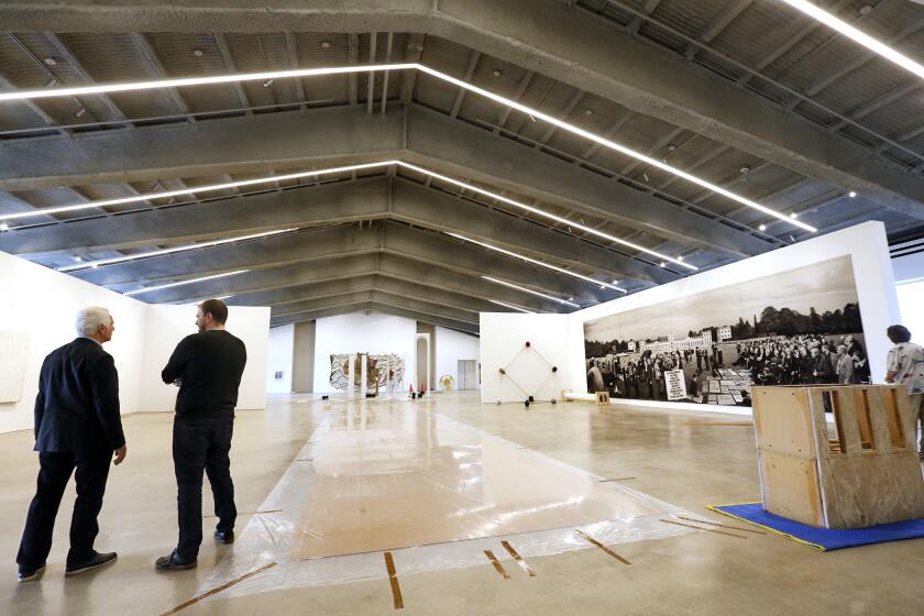 Maurice Marciano, left, founder of the Marciano Art Foundation on Wilshire Boulevard, surveys a partly installed gallery prior to his exhibition hall's opening in 2017.