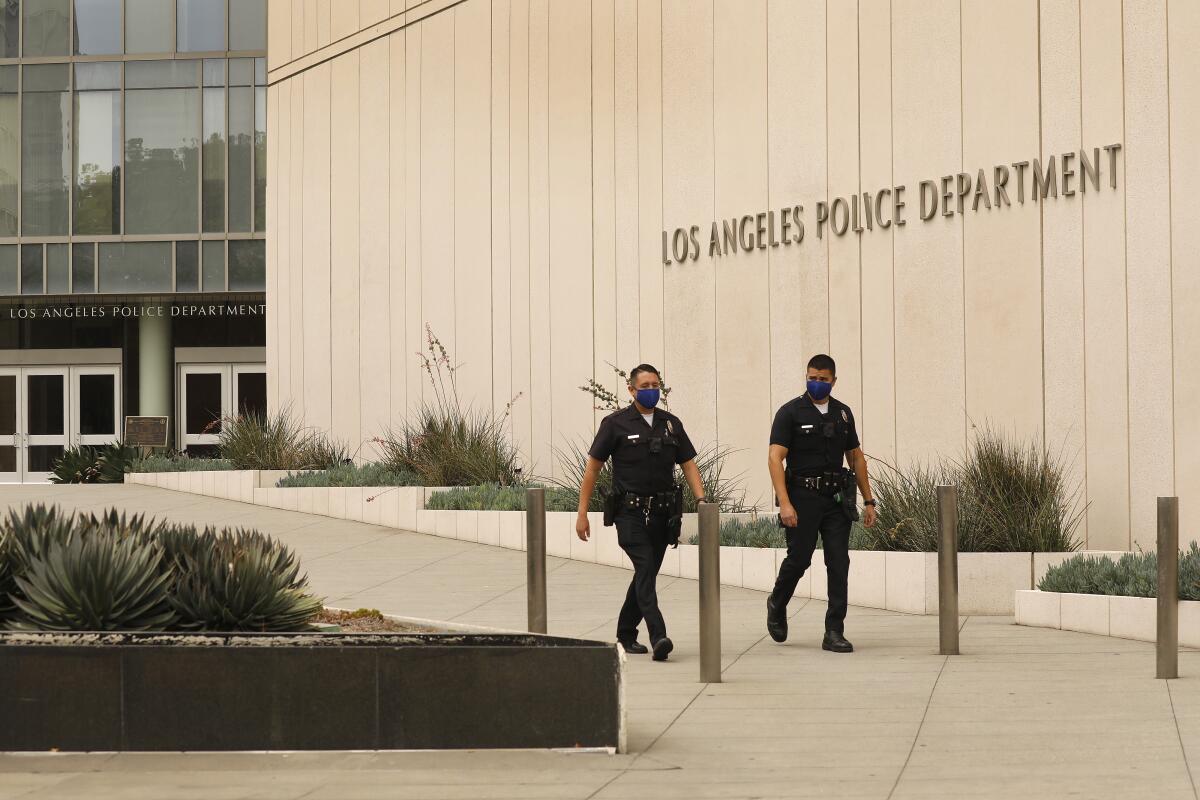 Two police officers walk outside LAPD headquarters