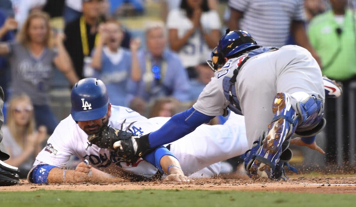 The Dodgers' Adrian Gonzalez is tagged at home plate by Cubs catcher Willson Conteras in the second inning in Game 4 of the NLCS. Gonzalez was called out, a ruling upheld after replay review.