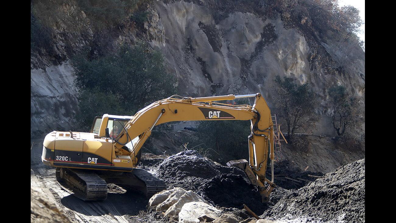 An excavator digs out mud and debris at the Upper Sunset Debris Basin, above Country Club Drive in Burbank on Thursday, Jan. 18, 2018. More than one week after a massive storm and destructive mud flow, work continues to clean out the 30-foot deep debris basin.