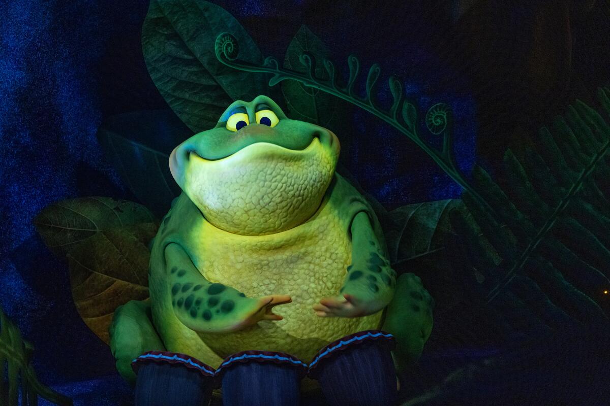 A large green animatronic frog, smiling, in a Disney World ride