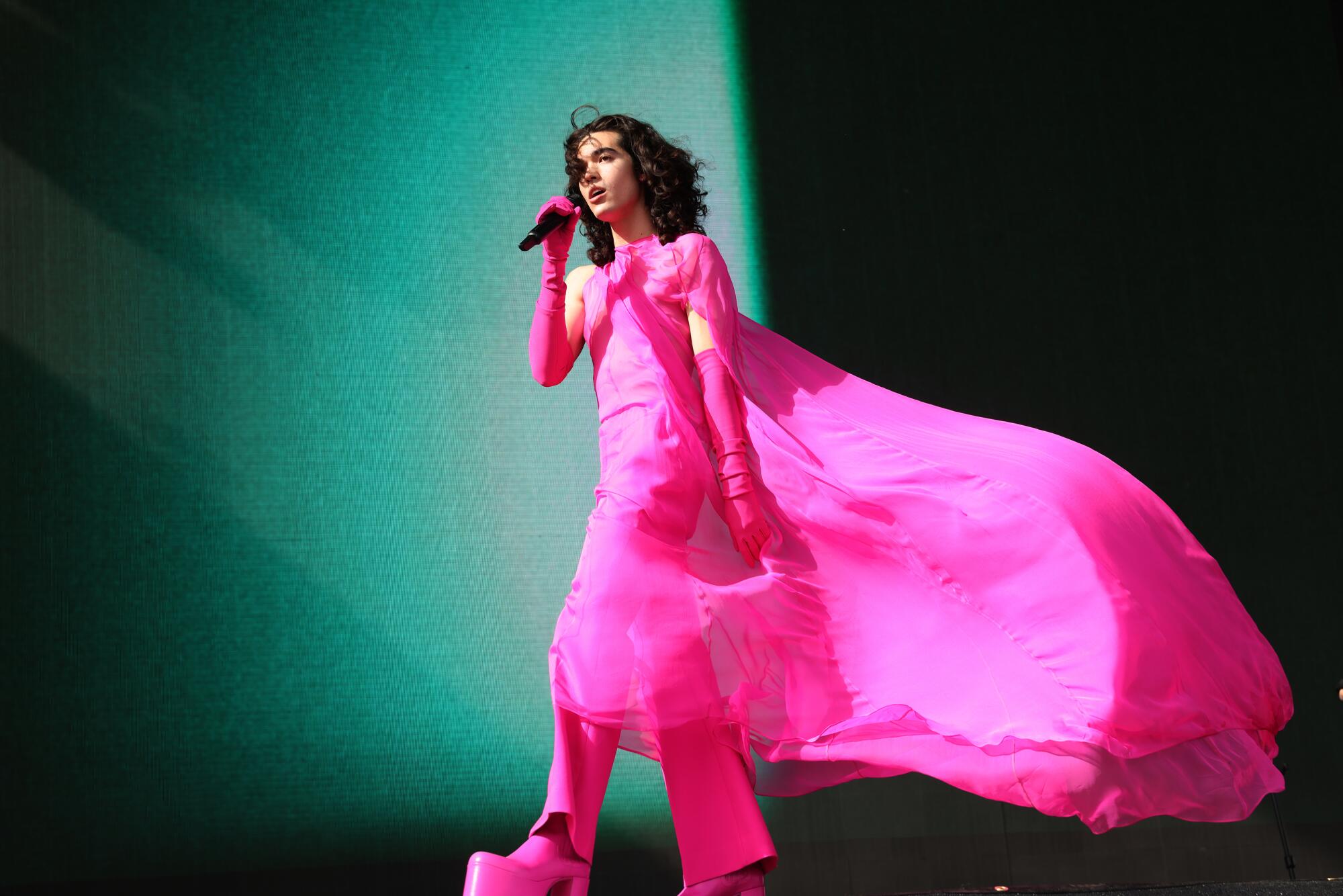Conan Gray walks with the wind in a hot-pink chiffon gown.