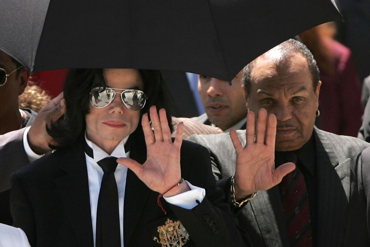 Michael Jackson, left, and his father, Joe Jackson, wave to fans on June 13, 2005, after Michael Jackson was cleared on all counts of child molestation during a trial at the Santa Barbara County courthouse.