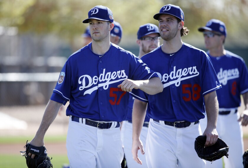 Dodgers pitchers Alex Wood (57) and Ian Thomas (58) walk between drills during a spring training baseball workout on Saturday.