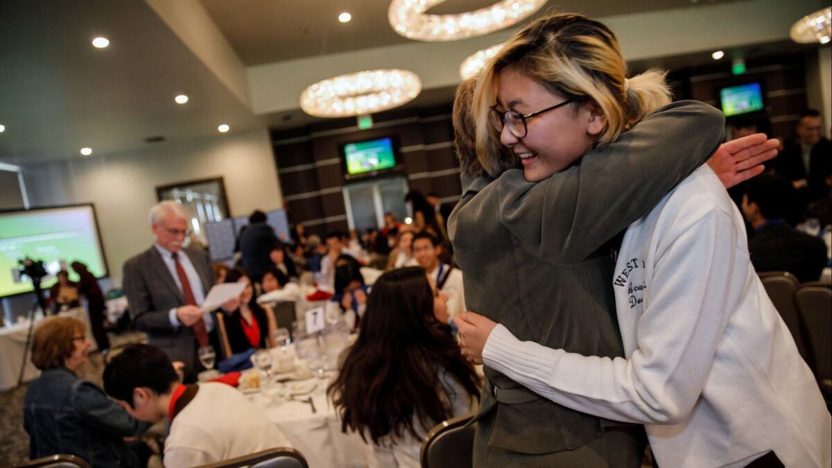 Amy Chung, from West High School in Torrance, gets a hug from Ann Cortina, the team's head coach, after their group won the L.A. County academic decathlon.