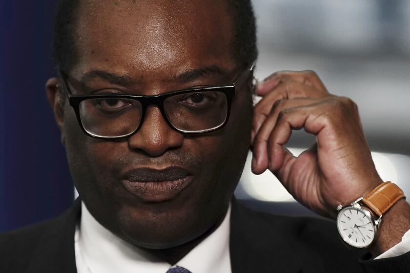 Chancellor of the Exchequer Kwasi Kwarteng speaking to the media ahead of the Conservative Party annual conference at the International Convention Centre in Birmingham. Picture date: Monday October 3, 2022. The British government has dropped plans to cut income tax for top earners, part of a package of unfunded cuts that sparked turmoil on financial markets and sent the pound to record lows. (Aaron Chown/PA via AP)