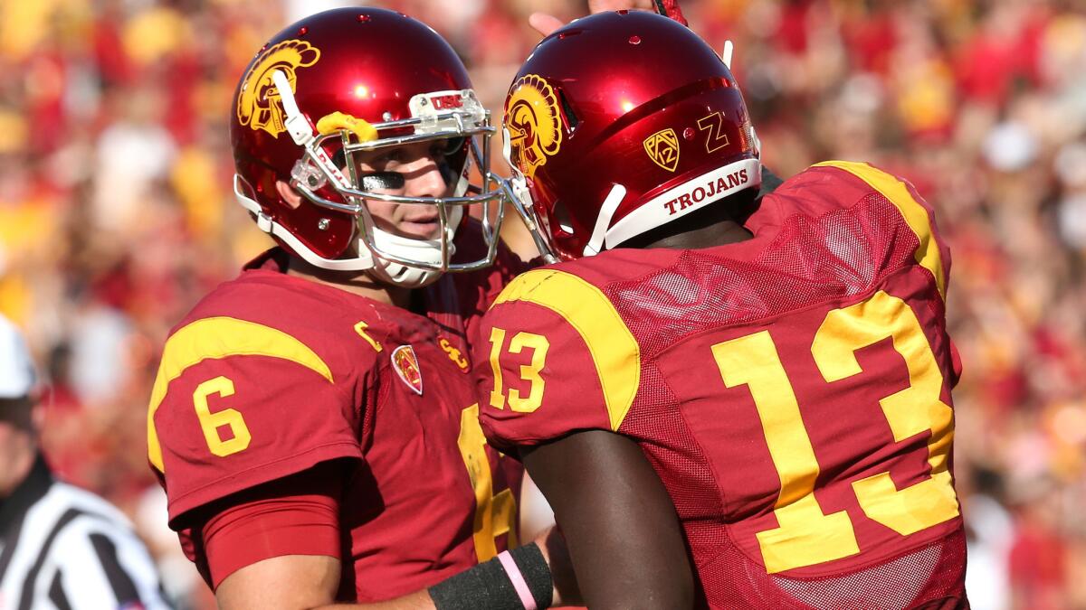 USC quarterback Cody Kessler, left, celebrates with tight end Bryce Dixon after the two connected on a touchdown pass in the first quarter of the Trojans' win over Colorado on Saturday.