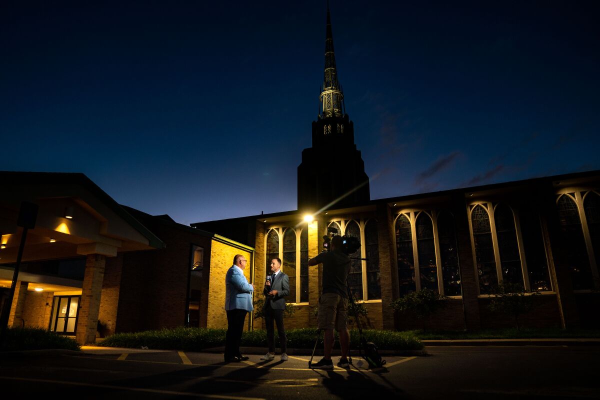 Two people speaking outside a church