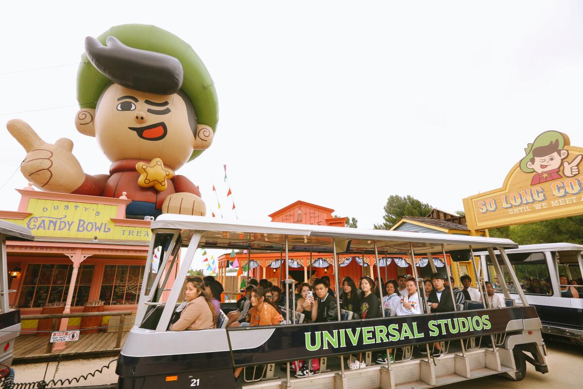 Visitors ride a tram tour a Universal Studios in 2023