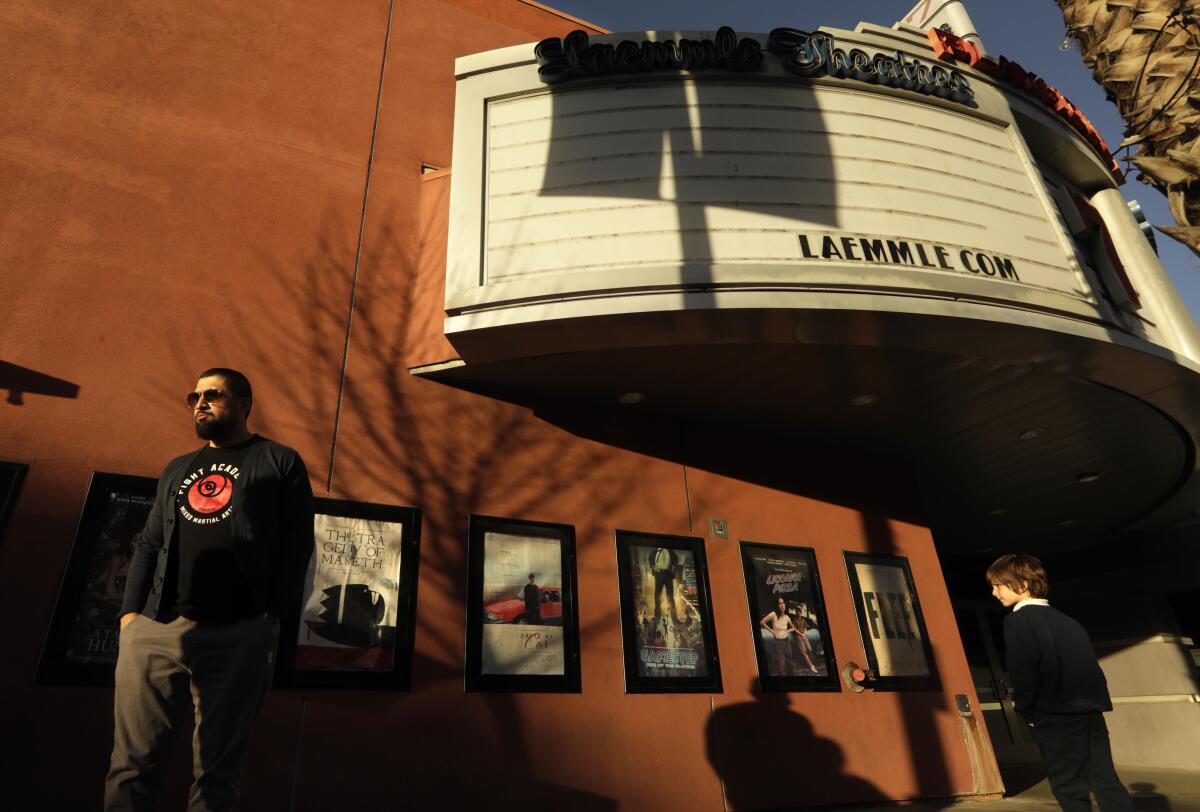 Pedestrians walk past Laemmle Theatre's Playhouse 7.