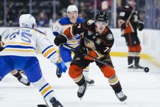 Anaheim Ducks right wing Frank Vatrano, right, clears the puck past Buffalo Sabres defenseman Connor Clifton during the first period of an NHL hockey game Tuesday, Jan. 23, 2024, in Anaheim, Calif. (AP Photo/Ryan Sun)