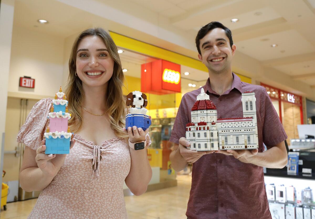 LEGO Masters contestants Lauren and Bryan Firks hold a few of their build creations.
