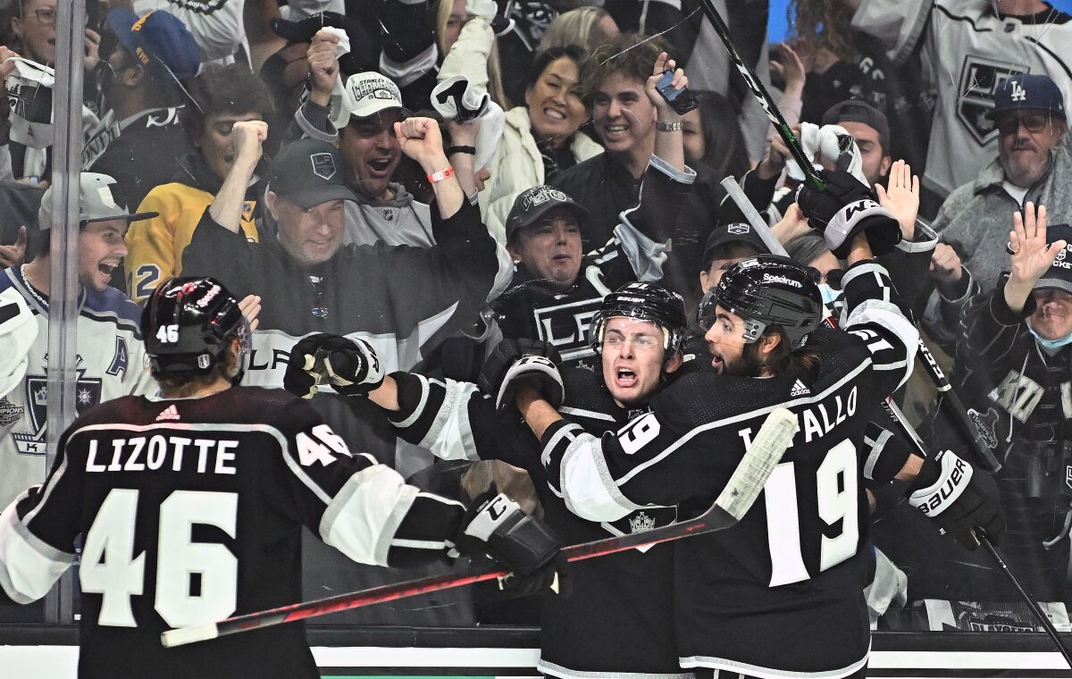Kings defenseman Troy Stecher celebrates with teammates Blake Lizotte and Alex Iafallo.