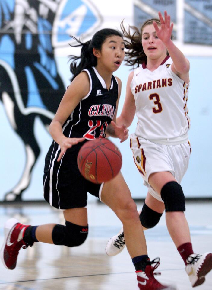 Glendale High's Jillian Yanai drives to the basket in a game against La Cañada High's Sarah Kurdoghlian at Arroyo High School in El Monte on Friday, Dec. 18, 2015.