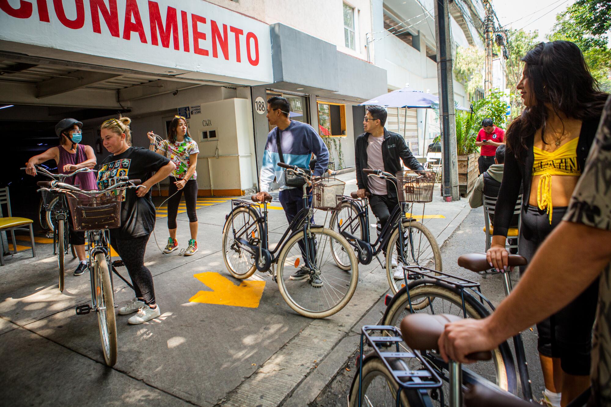  Tourists gather before departing on a bike tour of popular taco spots