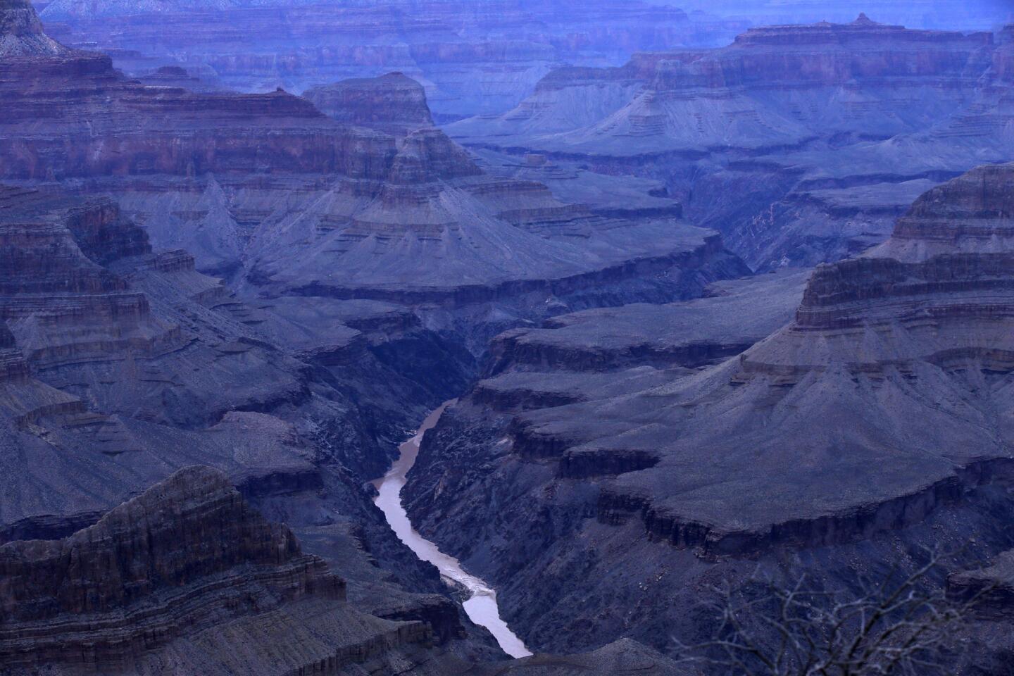 From Mojave Point on the South Rim of the Grand Canyon, the meandering Colorado River is seen at twilight, still carving its path.