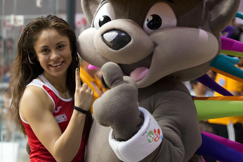 Mexico's Paola Longoria poses with Patchi, the Pan Am Games mascot, as she celebrates after winning gold in women's racquetball team competition at the Pan Am Games in Toronto, Sunday, July 26, 2015. (AP Photo/Rebecca Blackwell)